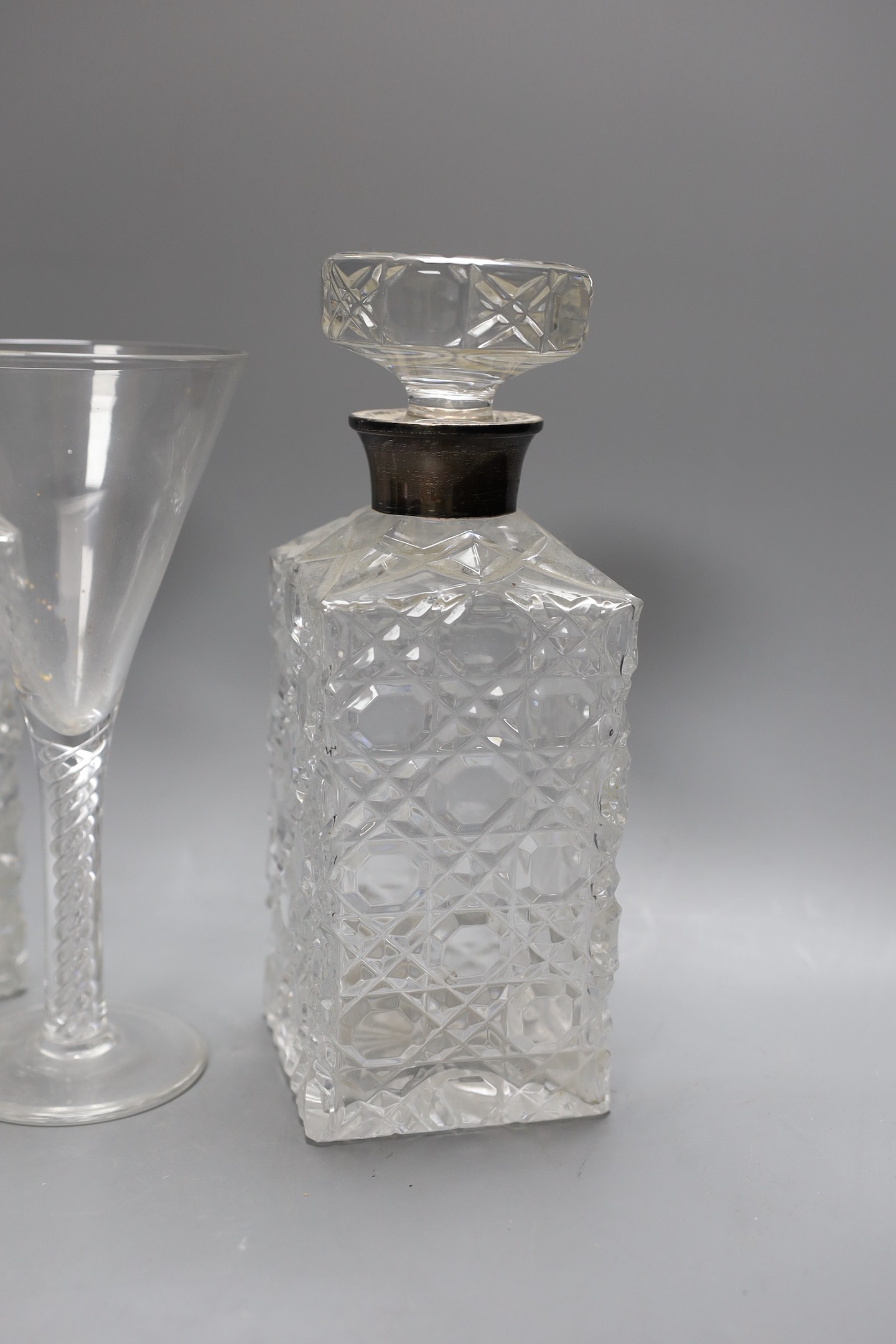A pair of silver mounted cut glass decanters and stoppers and an air twist stemmed goblet, decanters 24 cms high